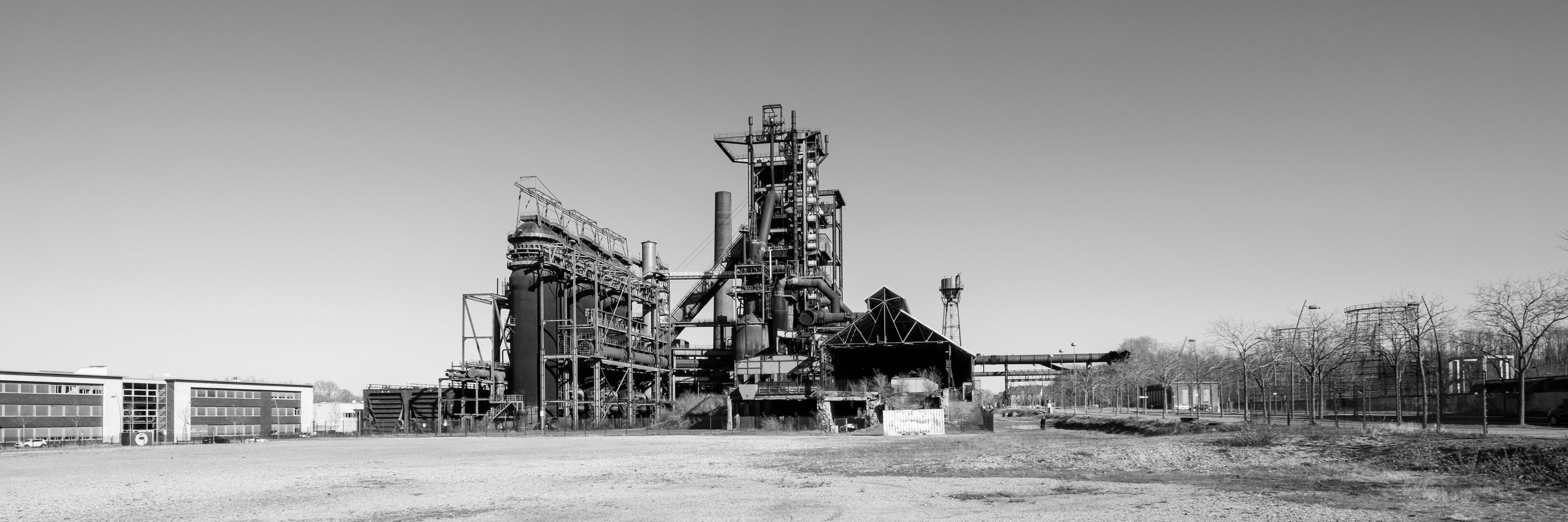An industrial complex with large structures and a dirt ground.
