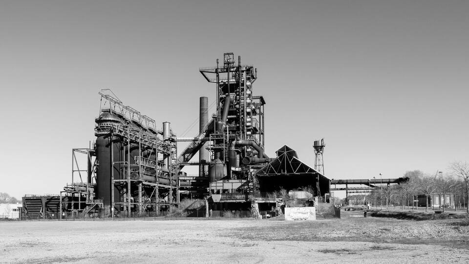 An industrial complex with large structures and a dirt ground.