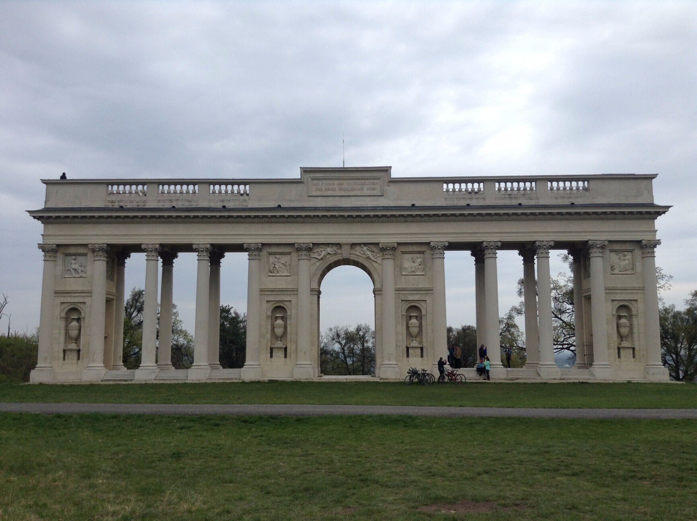 A large neoclassical archway with columns and decorative elements.