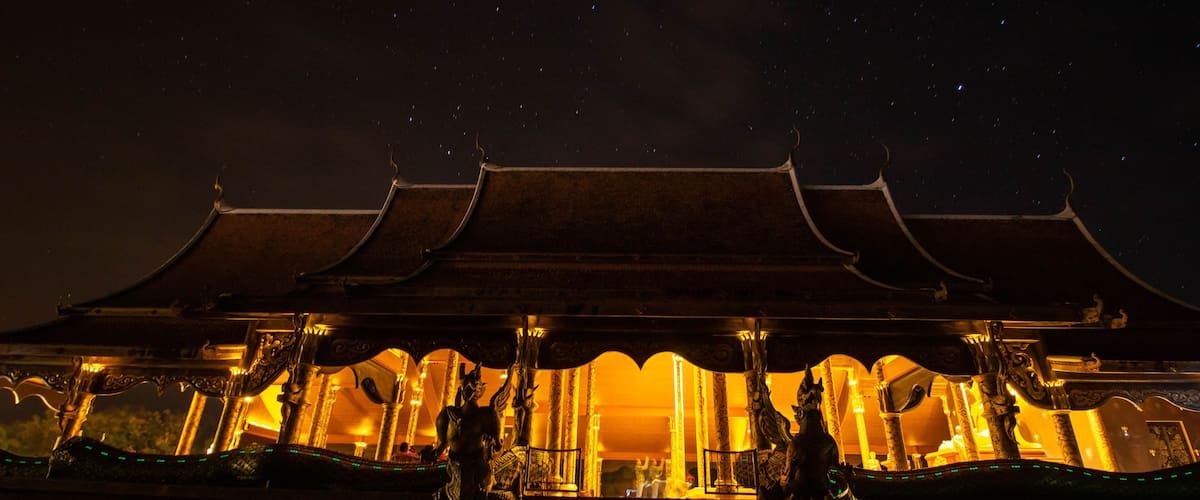 A traditional temple with ornate architecture and golden lighting at night.