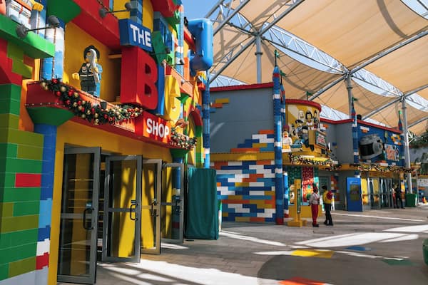 A colorful building with a LEGO-themed facade, a shop sign, and a large canopy structure.