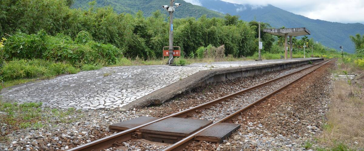 A railway track with a signal post and a shelter.