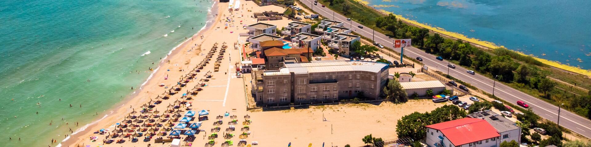 A coastal town with a beach, a road, and a clear blue sea.