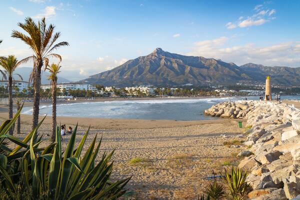 Puerto Banus Beach which includes a lighthouse, a beach and general coastal views