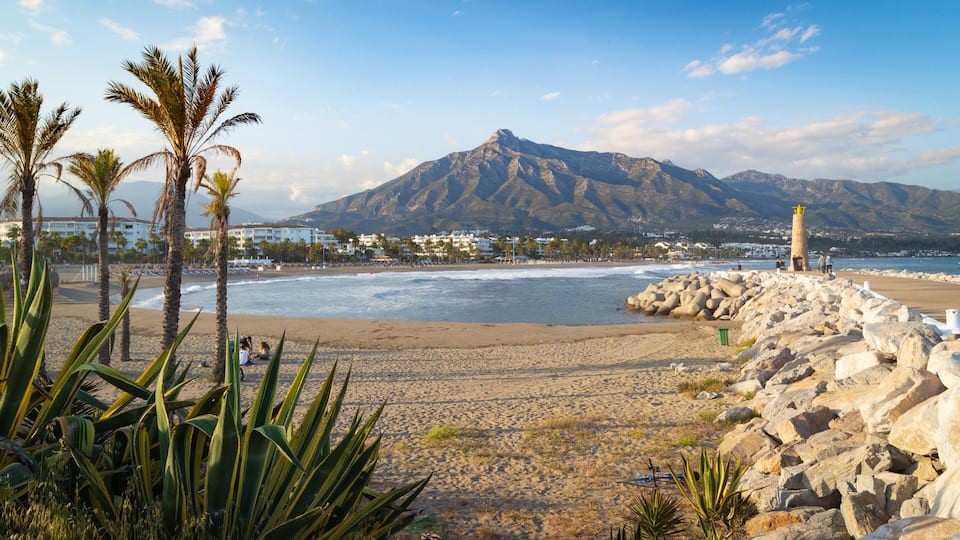 Puerto Banus Beach which includes a lighthouse, a beach and general coastal views