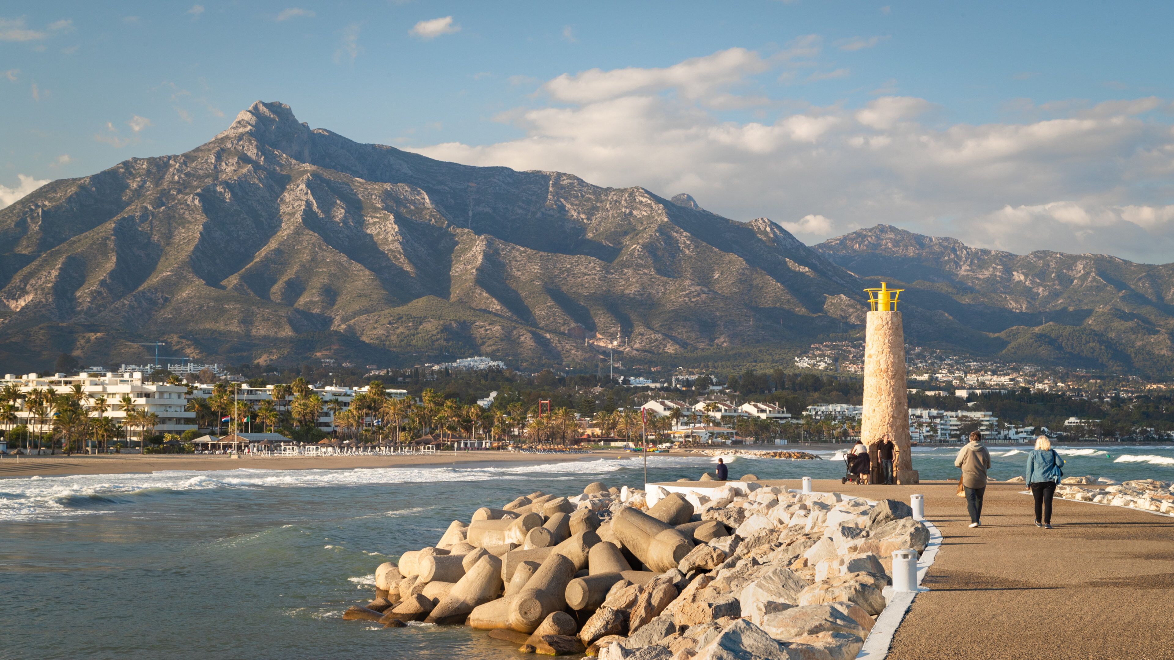 Puerto Banus Beach which includes a lighthouse, mountains and general coastal views