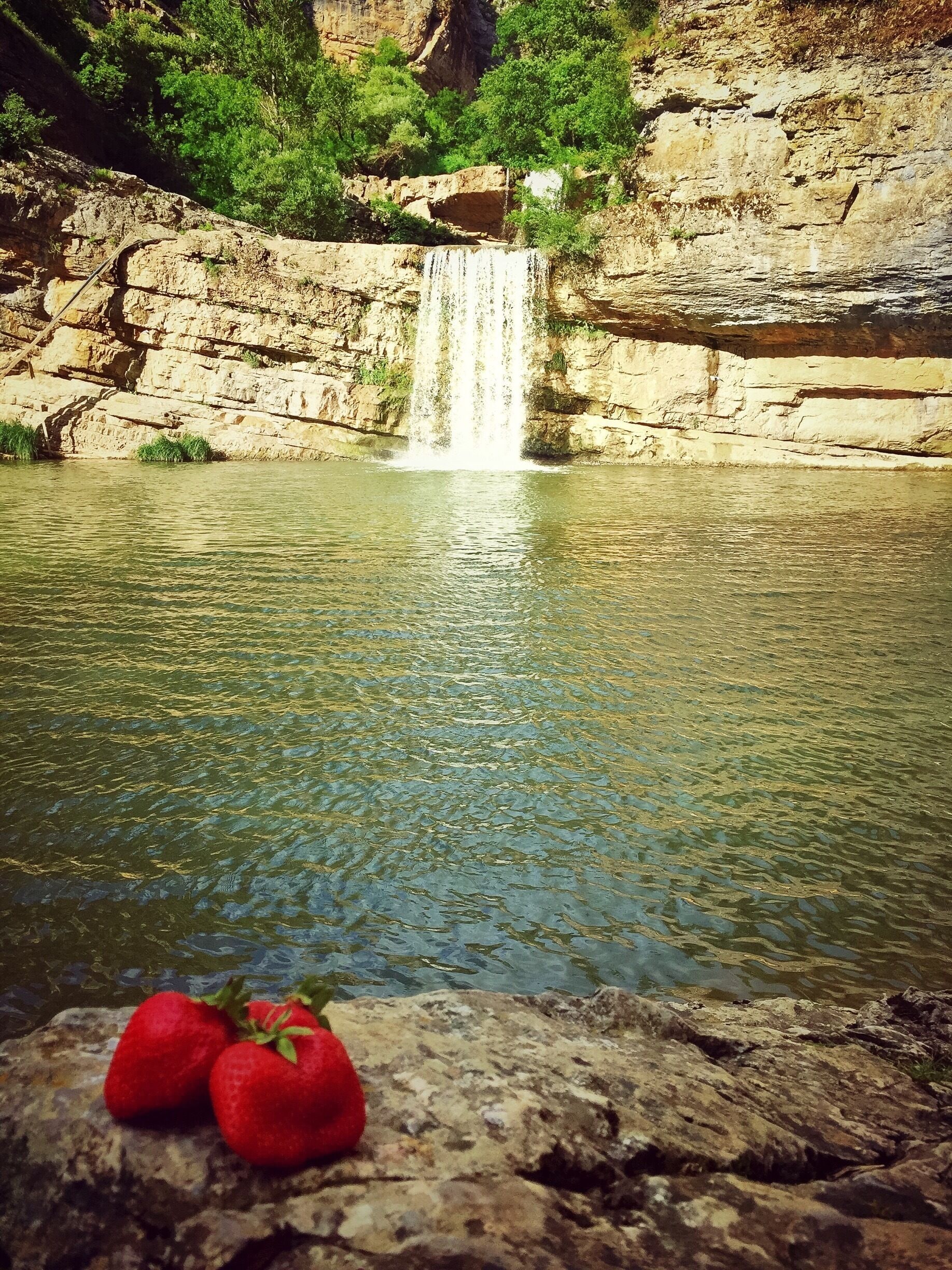 Uma cascata numa garganta rochosa, com águas cristalinas.