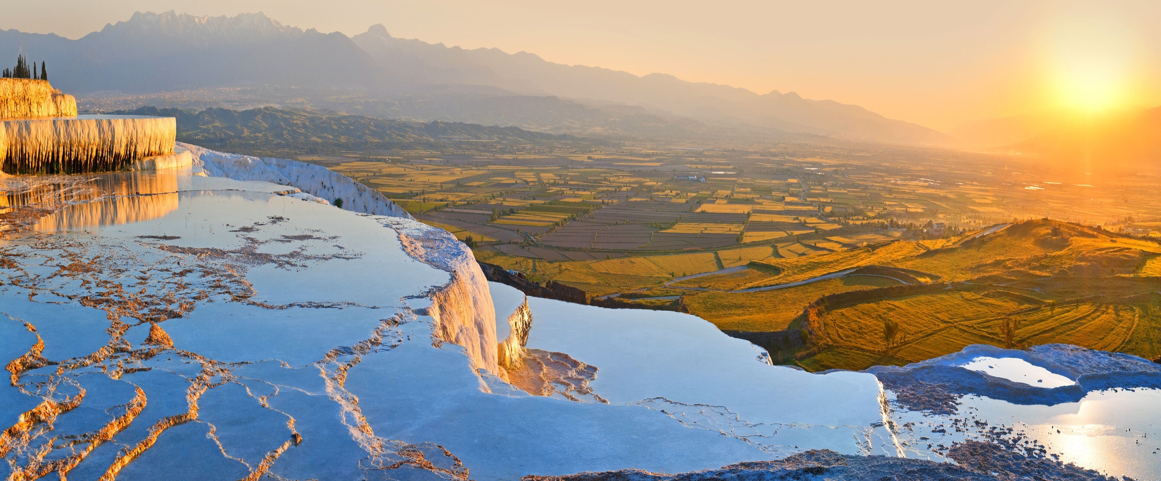 Panorama terraces from travertine in Pamukkale at sunset.