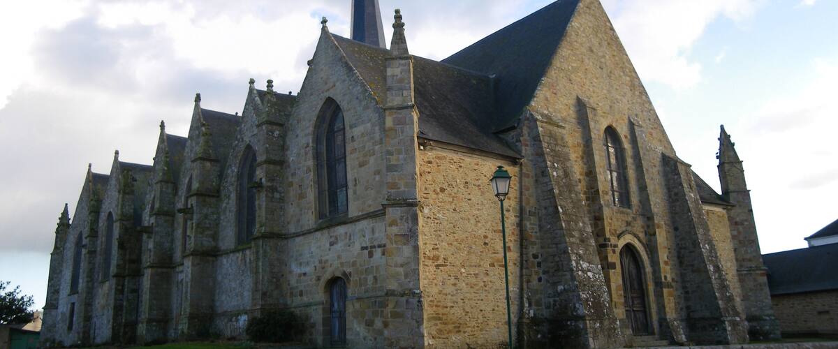 A historic church with a tall spire and arched windows.