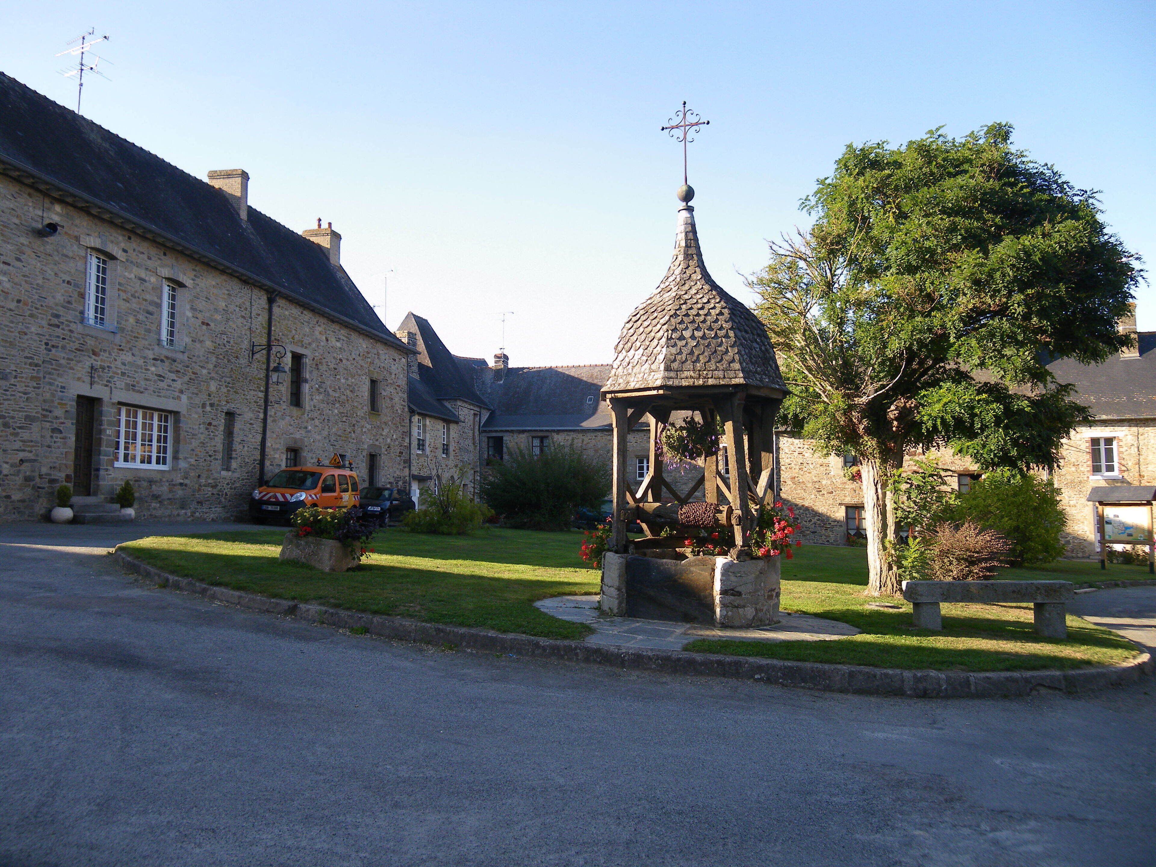 A stone building with a gazebo in a village square.