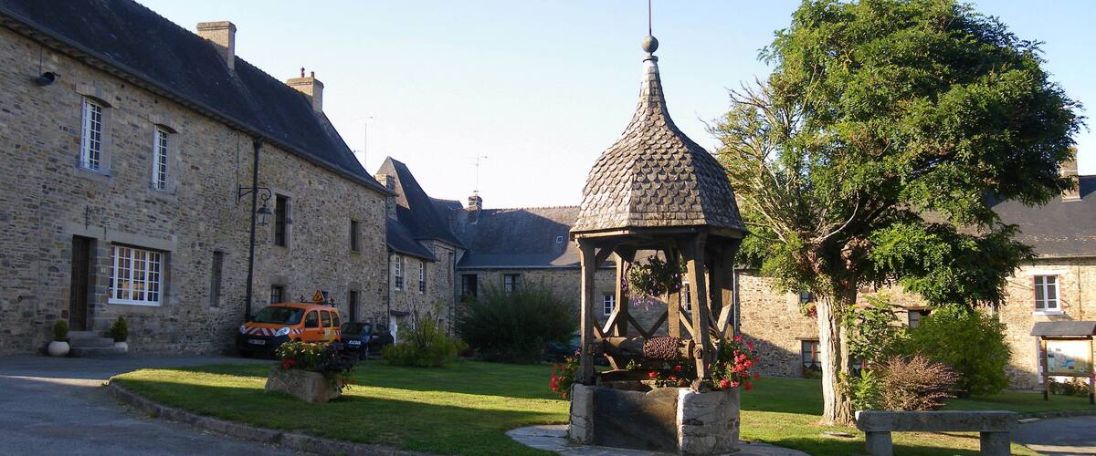 A stone building with a gazebo in a village square.