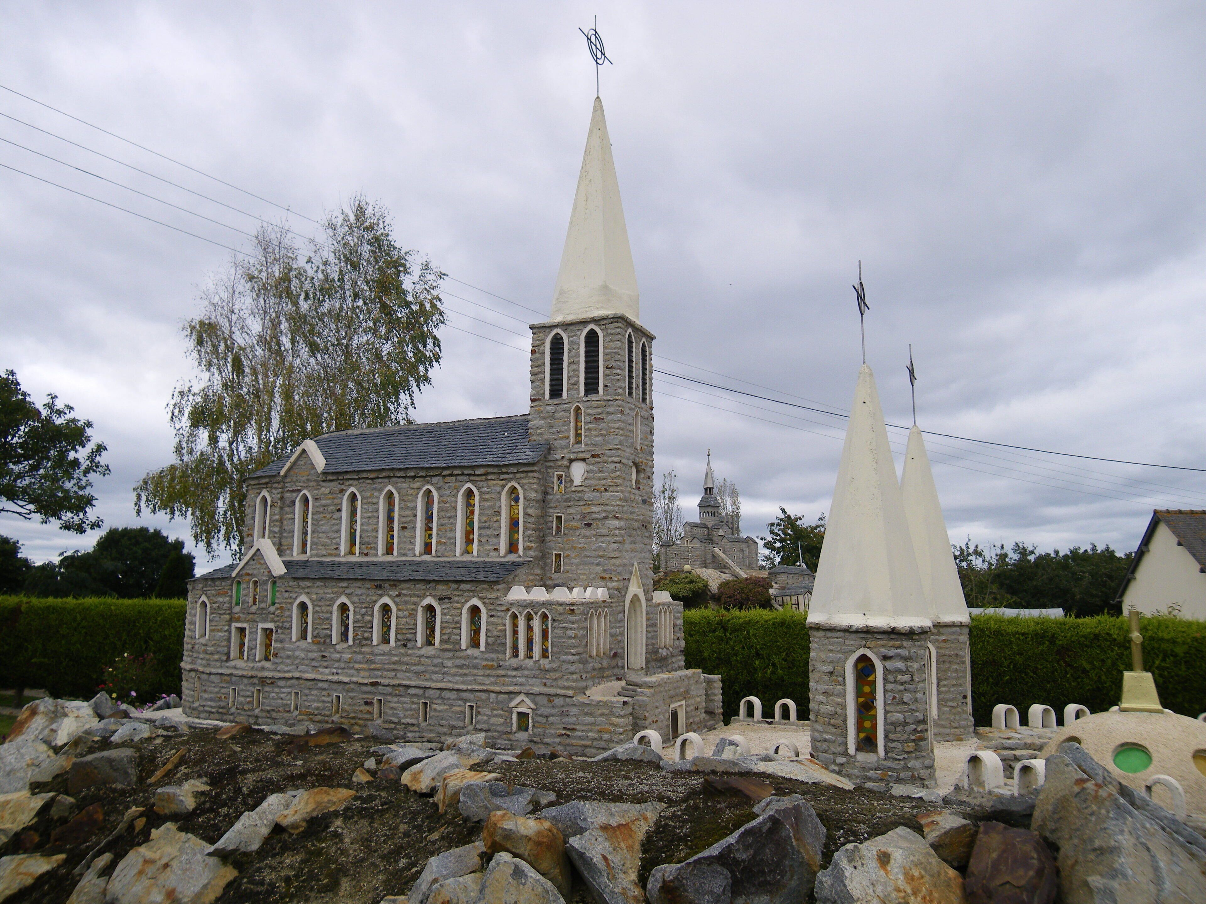 A model of a stone church with two spires and a bell tower.