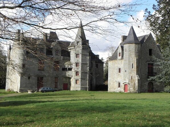 A large stone castle with multiple towers and a red door.