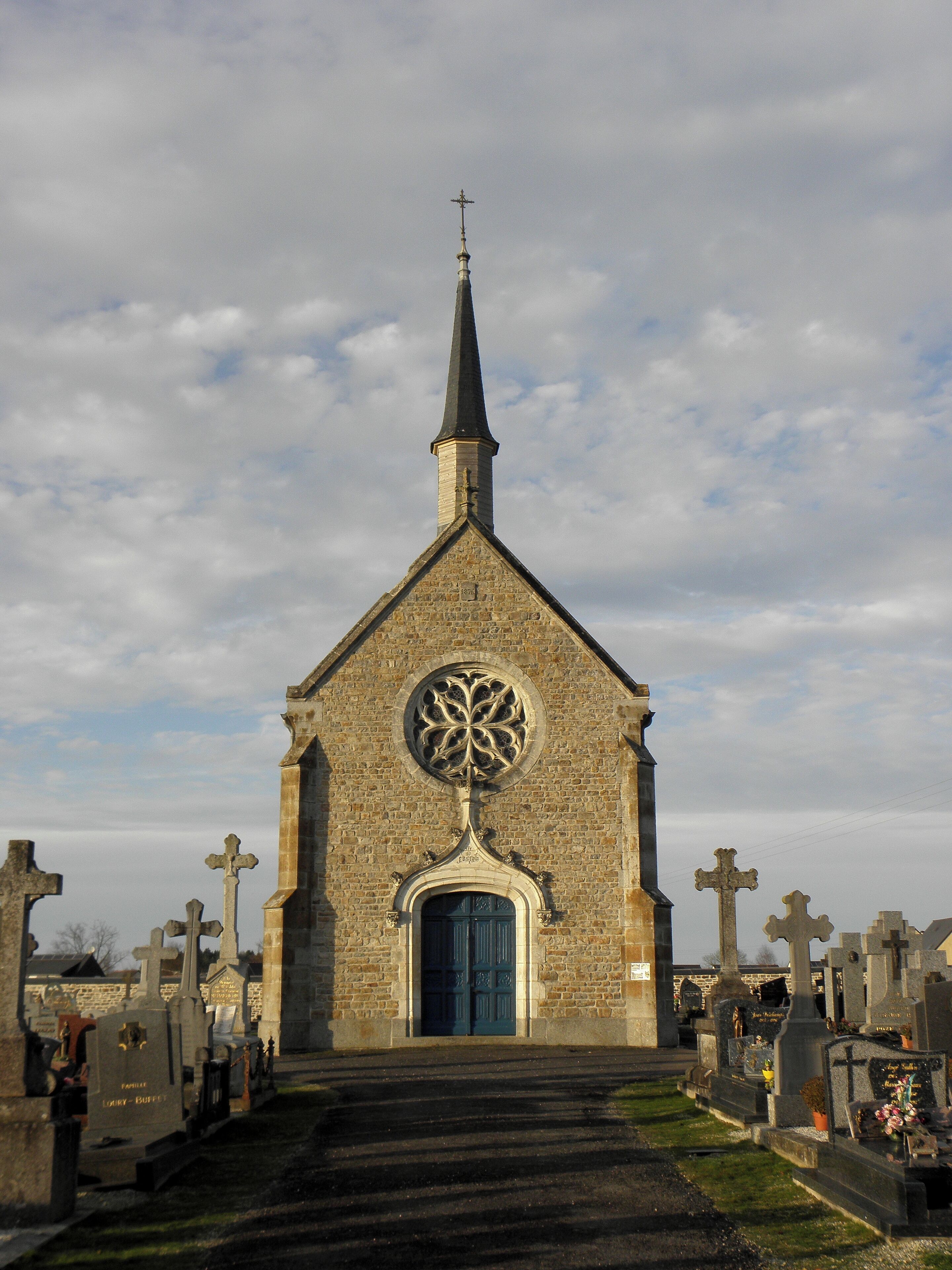 A church with a tall steeple and a circular stained glass window.