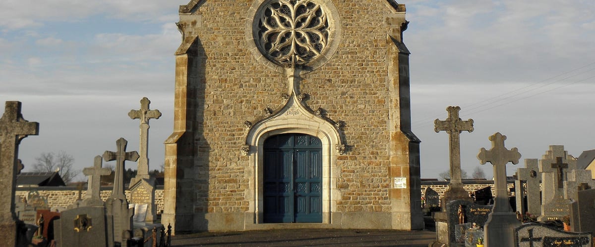 A church with a tall steeple and a circular stained glass window.