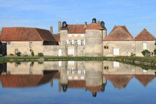 A castle with a moat and a clear reflection.
