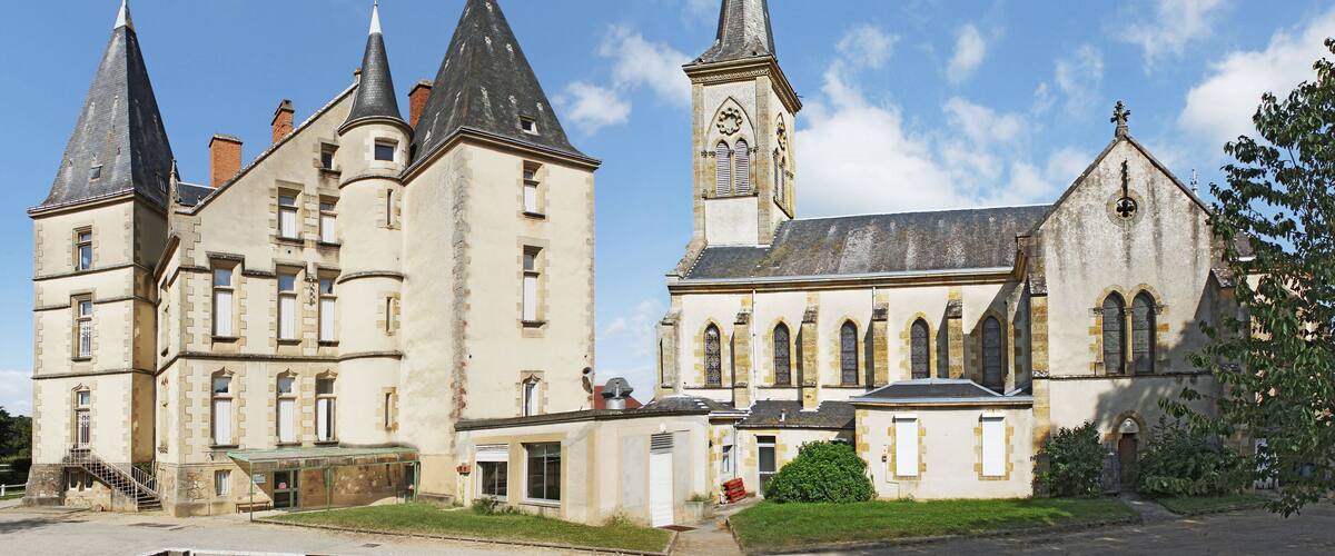 A historic building with multiple spires and a clock tower.