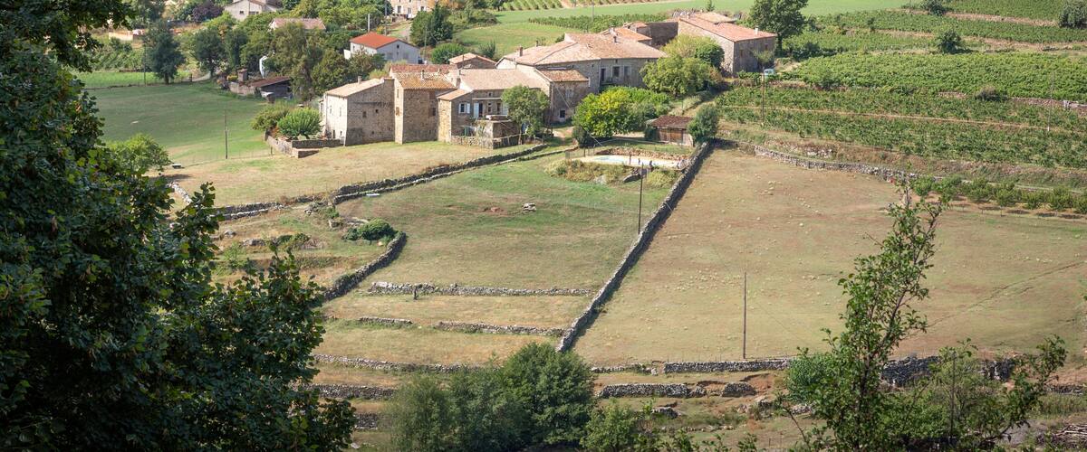 A rural landscape with stone walls, terraced fields, and traditional houses.