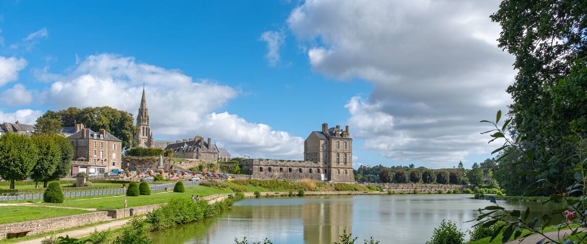 A historic town with a river, a church, and a castle.