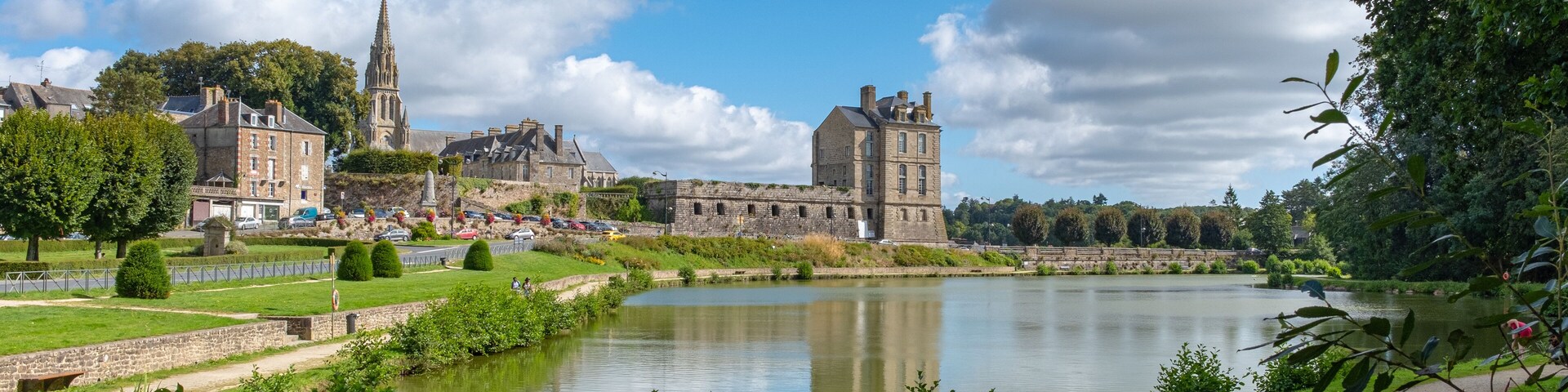 A historic town with a river, a church, and a castle.