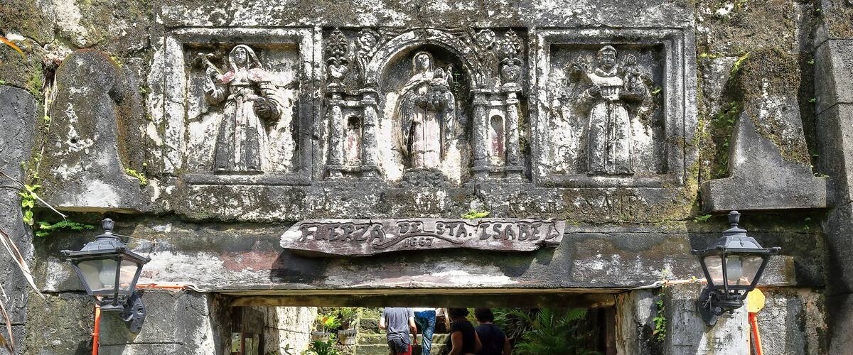 A stone archway with carvings and a sign reading "Feria de Sta. Isabel".