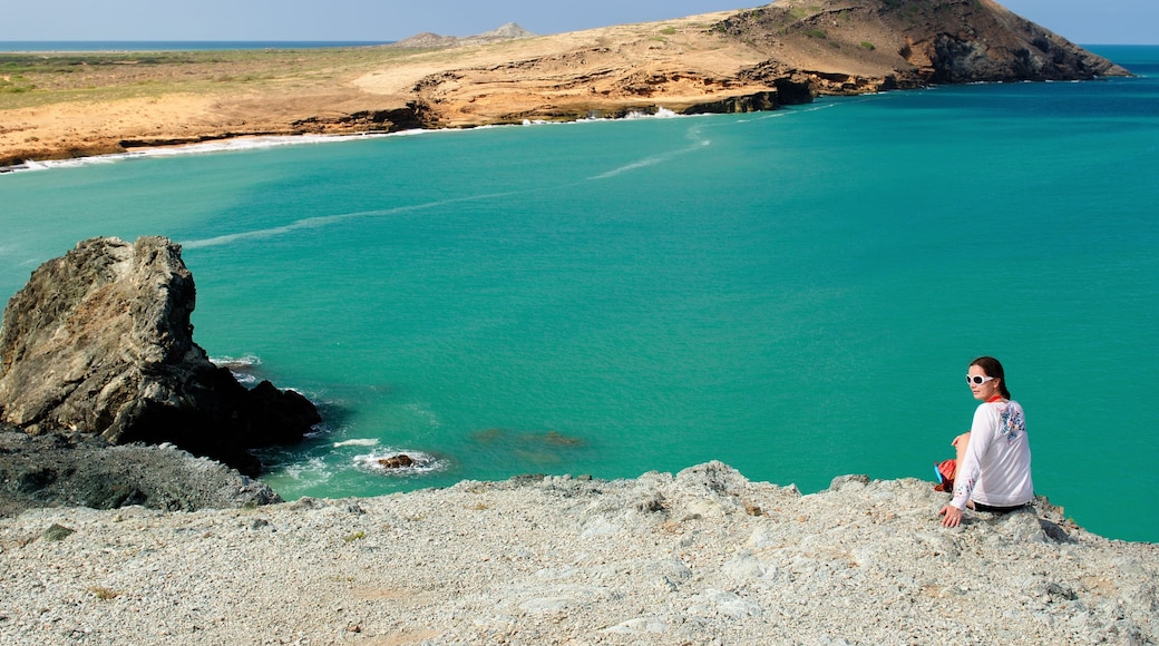 Tourist on the wild coastal desert of Penisula la Guajira near the Cabo de la Vela resort. Pilon de Azucar beaches of the Caribbean coast with turquoise water and orange sand