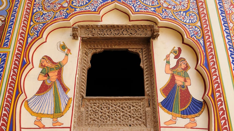 A detailed mural with two dancing figures, ornate architectural elements, and a central void.