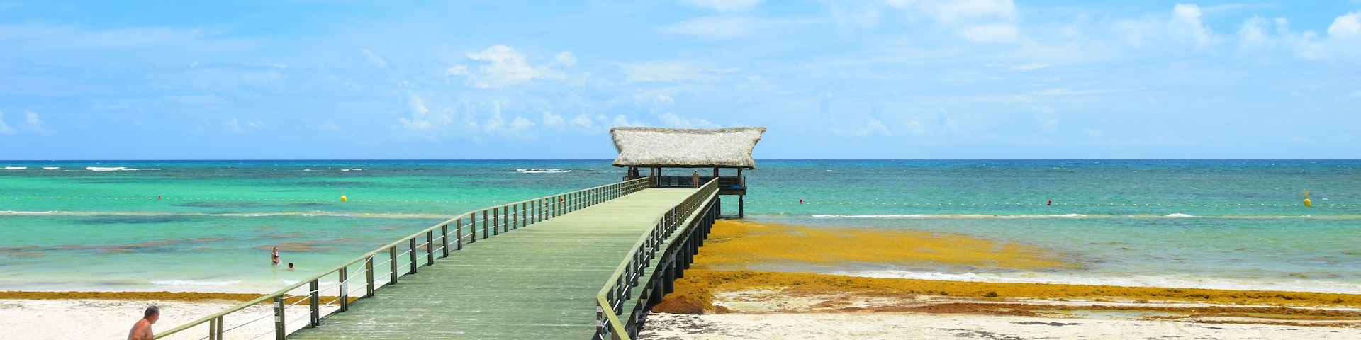 El Cortecito, Punta Cana, Dominican Republic- June 12, 2025: People walking along the coastline and sunbathing on one of the best beach in Caribbean area. Lots  of seaweed, specifically Sargassum.