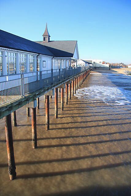 A pier extending into the water with a building at the end.