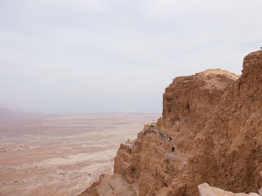 Une falaise rocheuse dotée d’une plateforme d’observation et offrant une vue sur un vaste paysage désertique.