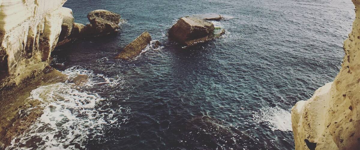 A coastal scene with white cliffs and the ocean.