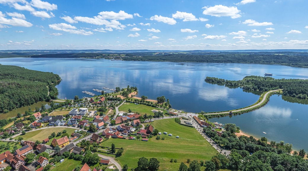 Un pueblo a orillas de un lago, con casas, muelles y cielo despejado.