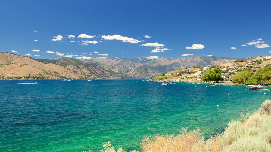 Un lago azul y transparente rodeado de montañas y casas.