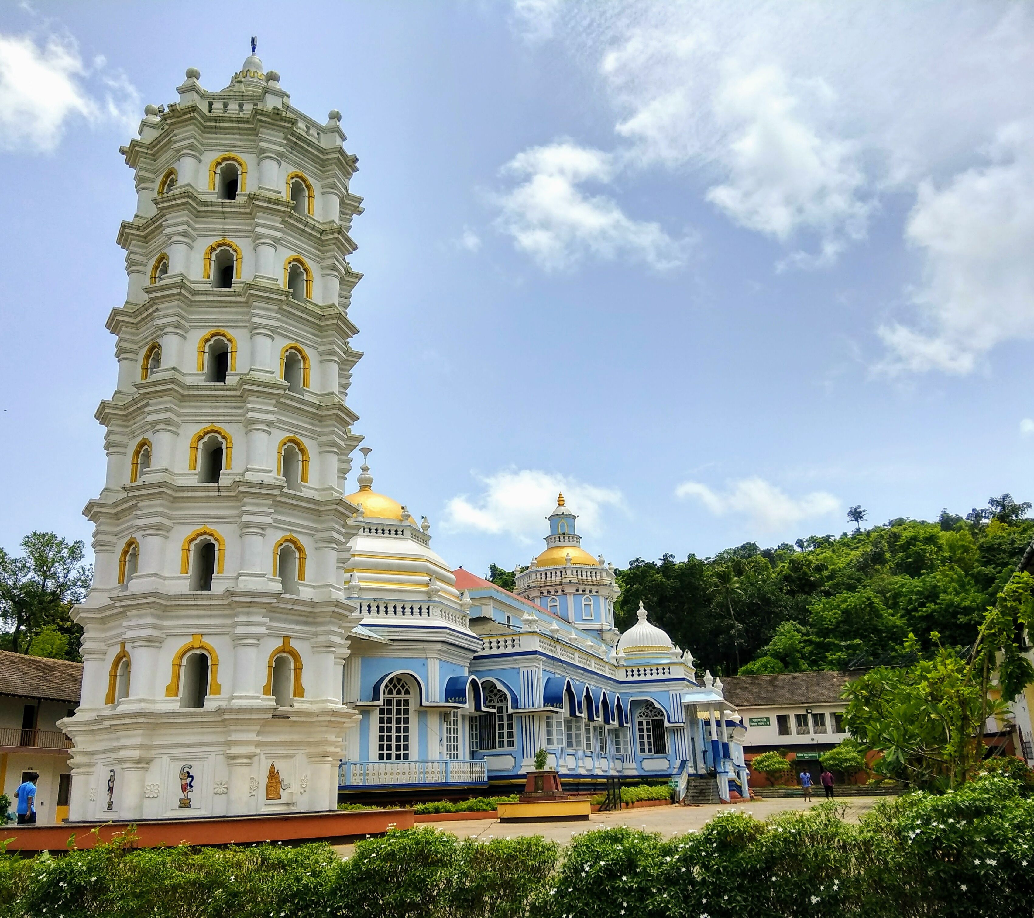 A white and blue church with multiple domes and a tall bell tower.