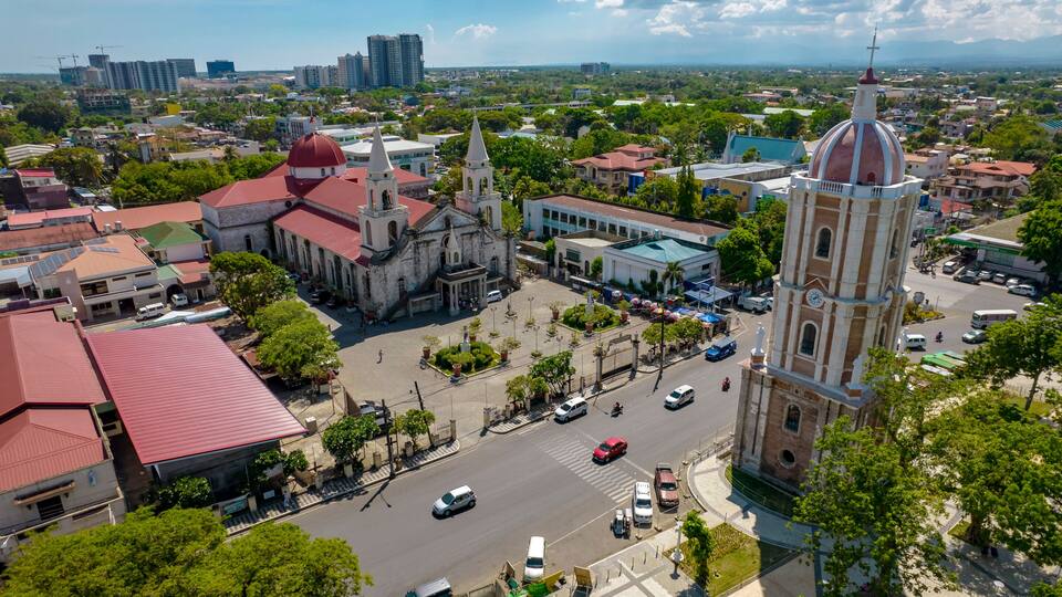 A cityscape with a prominent church, a clock tower, and surrounding buildings.