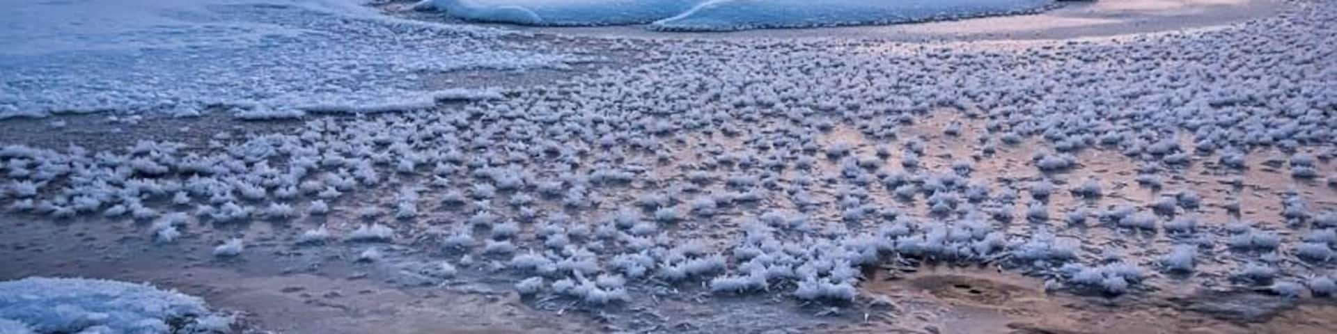 A frozen lake with a mountain in the background.