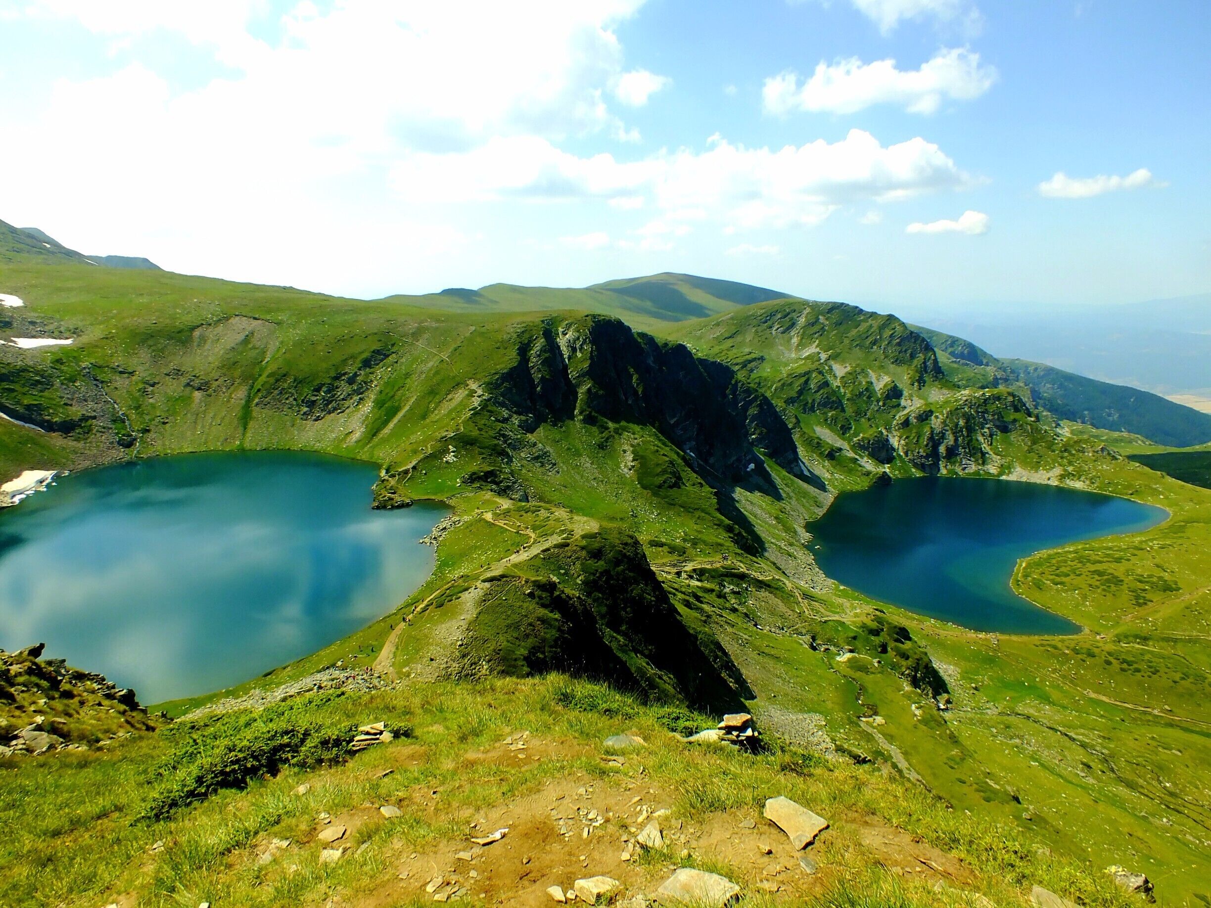 A mountainous landscape with two lakes and a hiking trail.
