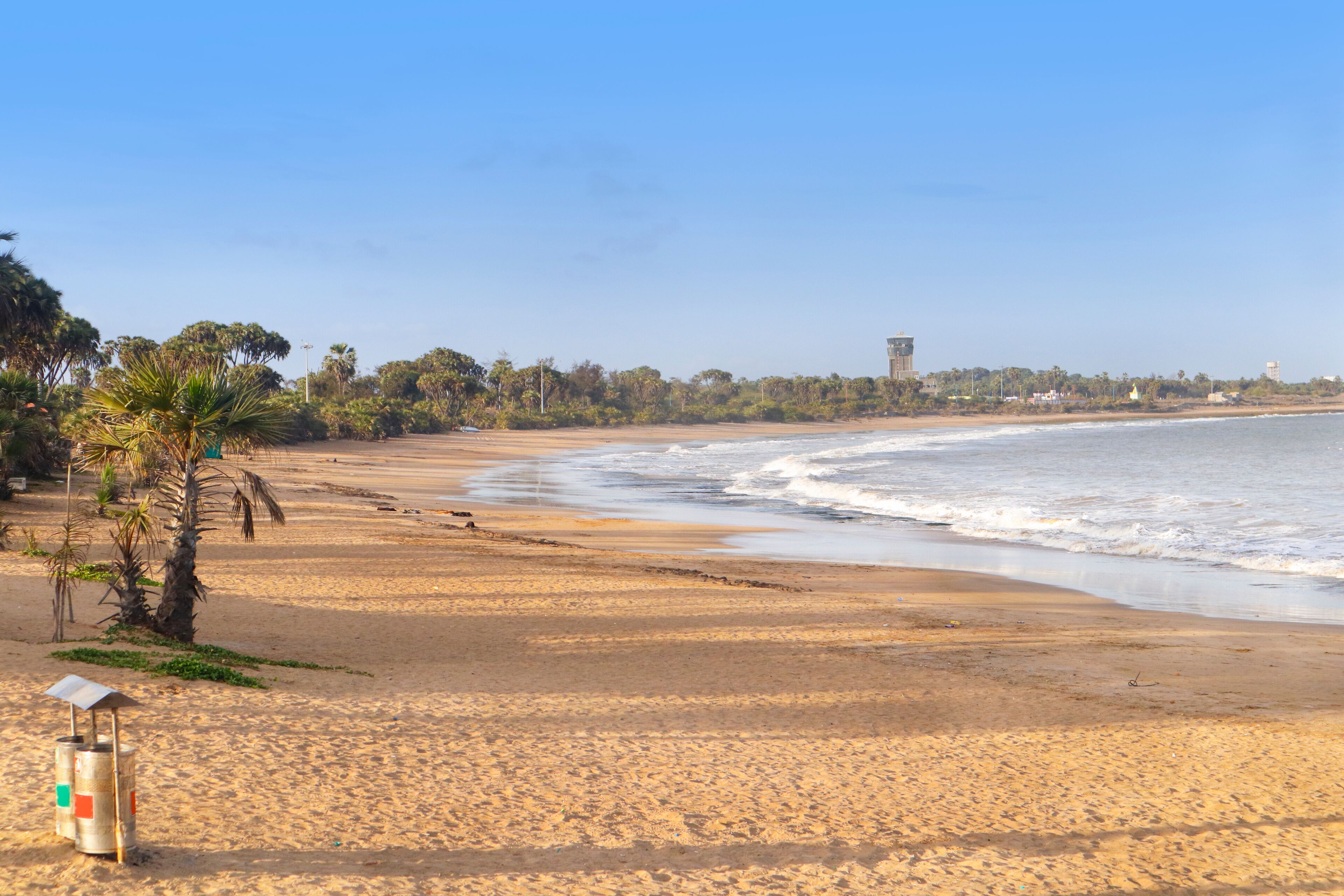Beautiful empty sandy Nagaon beach with it's blue water in the distance at Diu, Gujarat, India. The brown muddy water and with a sandy beach. view of Arabian. The Indian ocean and iconic font of diu