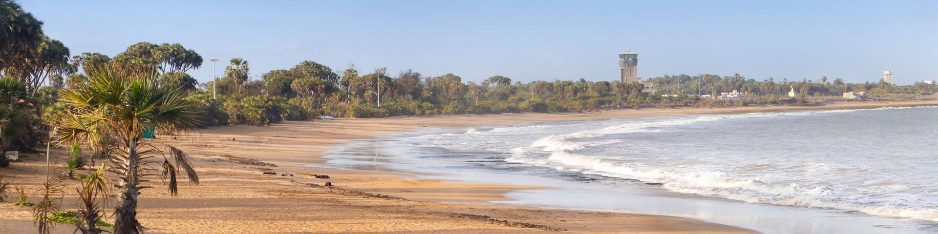 Beautiful empty sandy Nagaon beach with it's blue water in the distance at Diu, Gujarat, India. The brown muddy water and with a sandy beach. view of Arabian. The Indian ocean and iconic font of diu