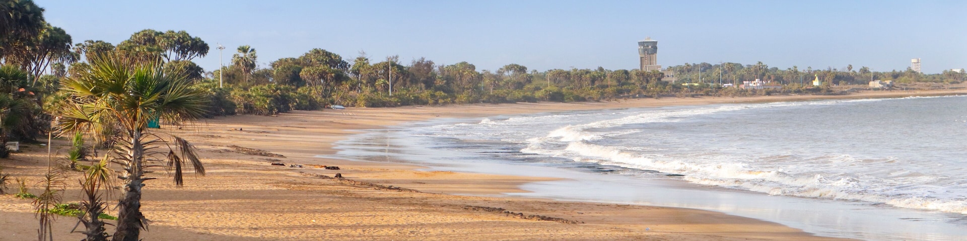 Beautiful empty sandy Nagaon beach with it's blue water in the distance at Diu, Gujarat, India. The brown muddy water and with a sandy beach. view of Arabian. The Indian ocean and iconic font of diu