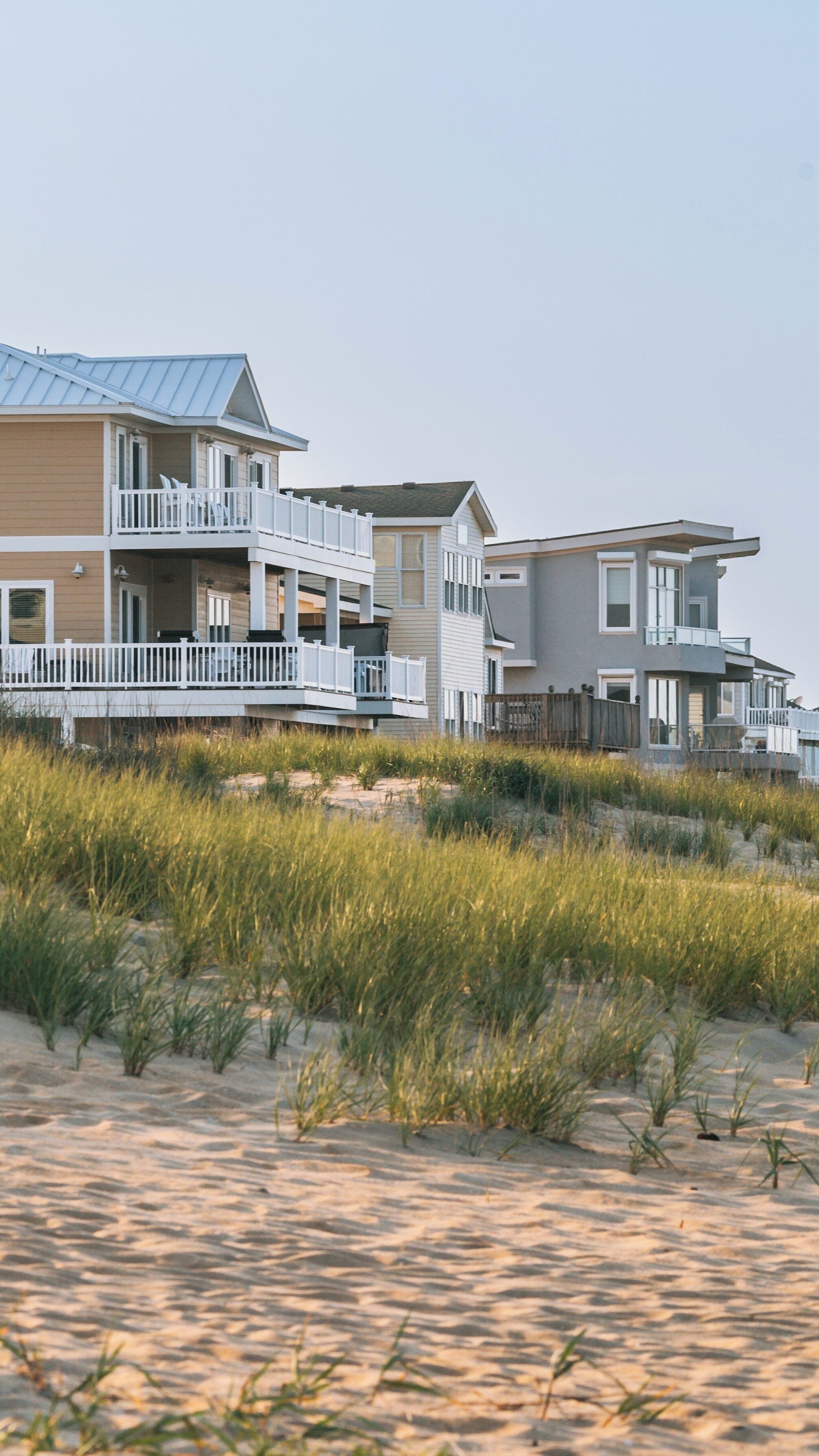 Beautiful Sandridge Beach in Virginia Beach showcases charming homes and coastal grasses under a serene sky during sunset