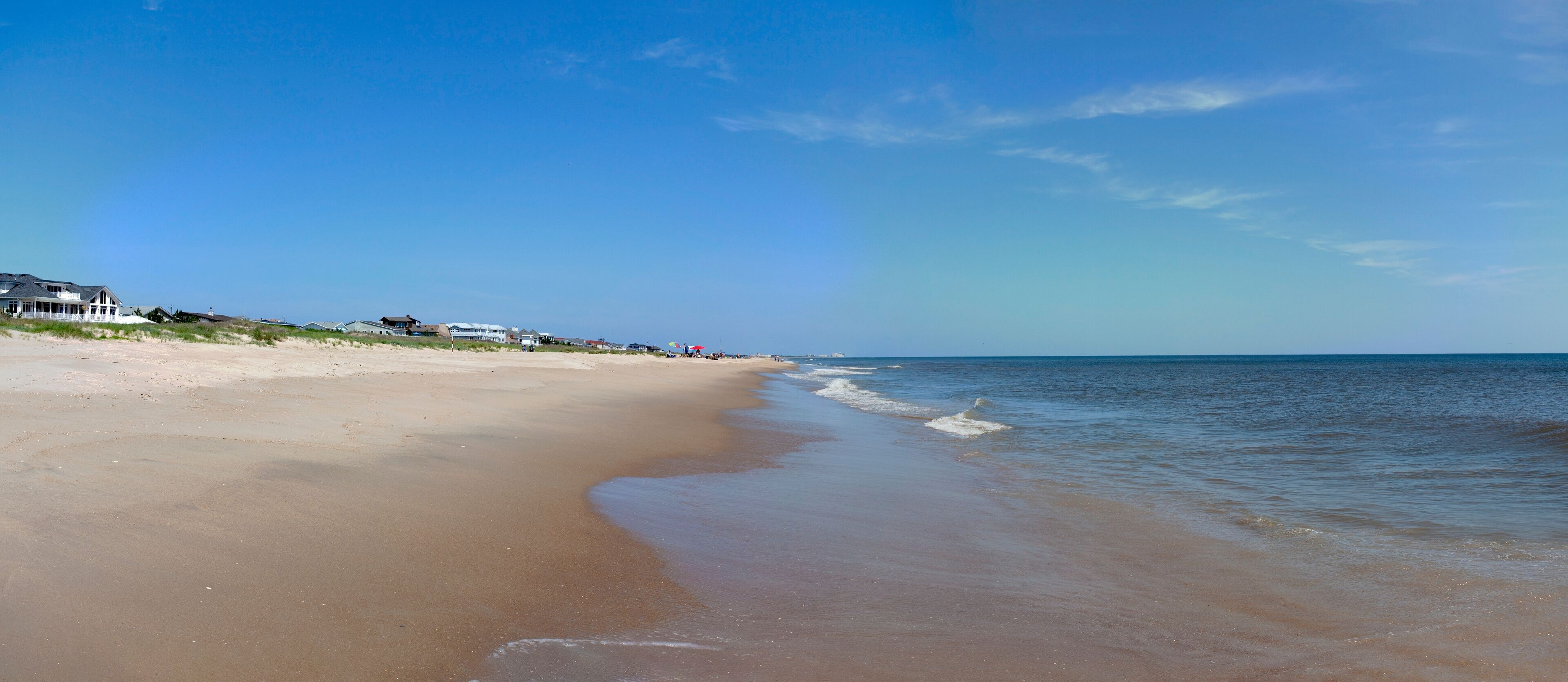 Sandbridge, Virginia beach panorama under blue sky.