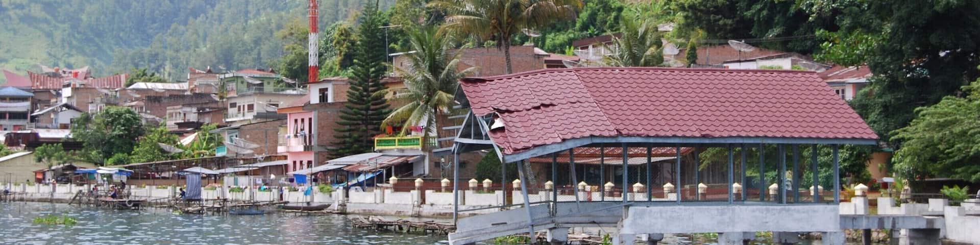 These brick houses come right up to the edge of the volcanic crater lake, Lake Toba. The remains of the prehistoric volcano are absolutely stunning with lush green hills that drop straight into the lake.