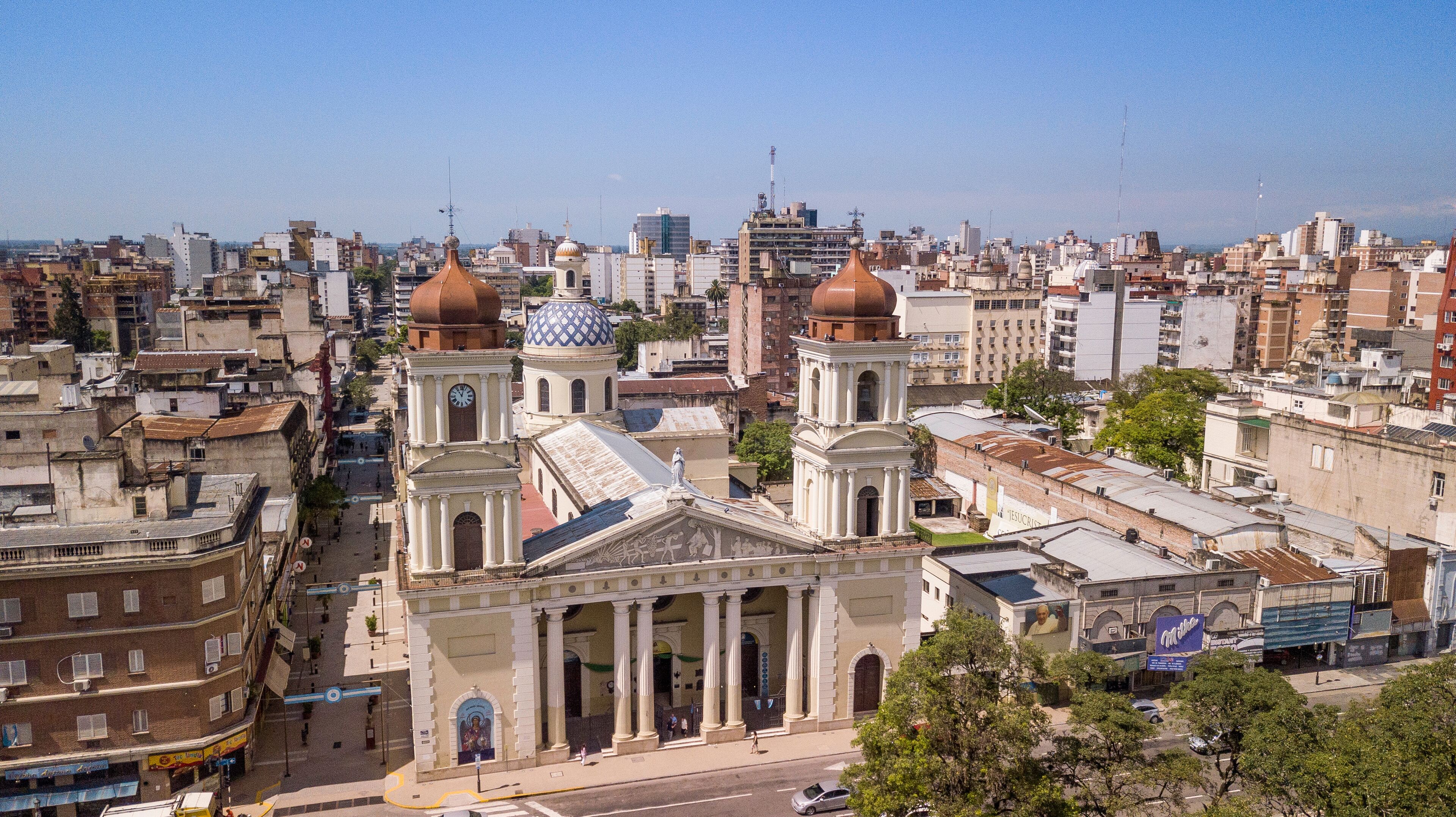 A cityscape with prominent historical buildings, including a church with a dome and a clock tower.