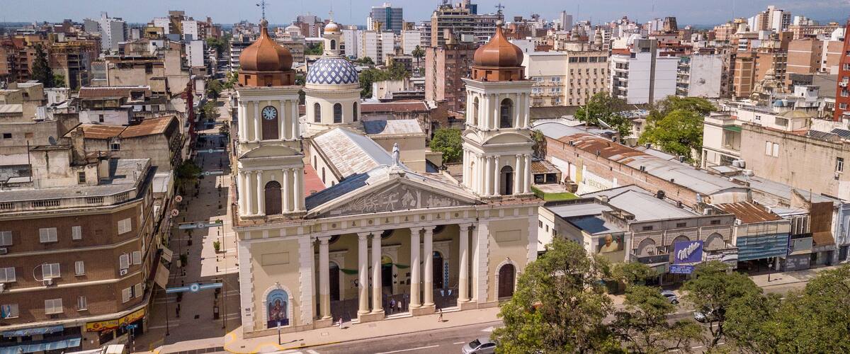 A cityscape with prominent historical buildings, including a church with a dome and a clock tower.