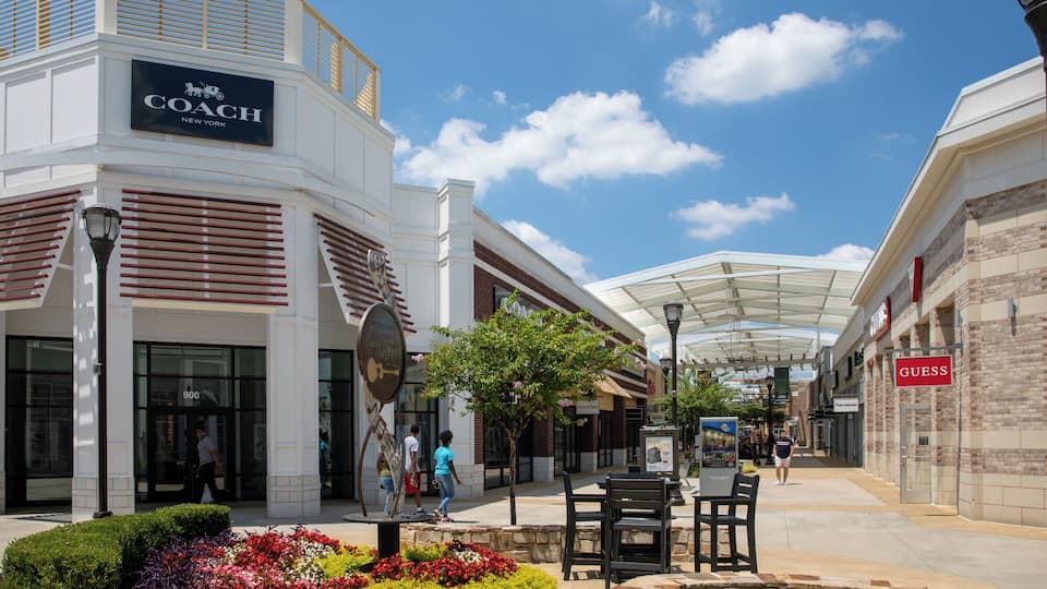 A shopping mall with stores like Coach and Guess.