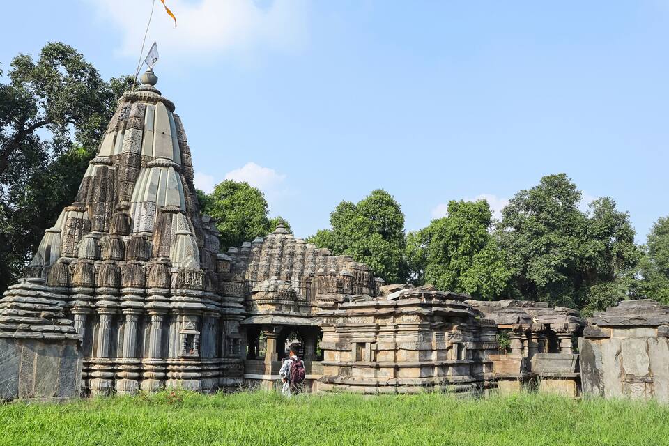 An ancient stone temple with intricate carvings and a flag on top.