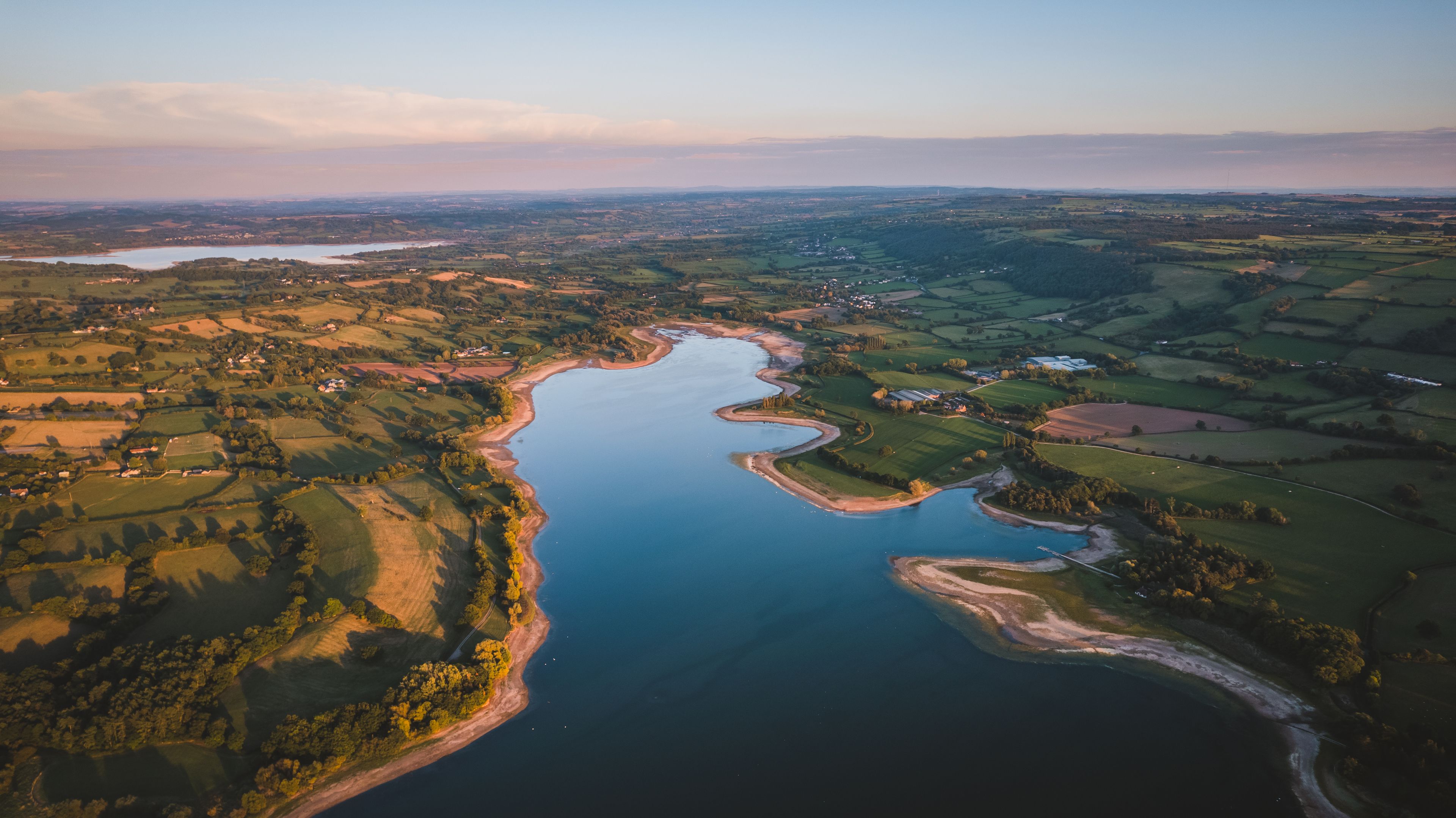 Vista aérea de un río serpenteando a través de un paisaje con campos y pequeños poblados.