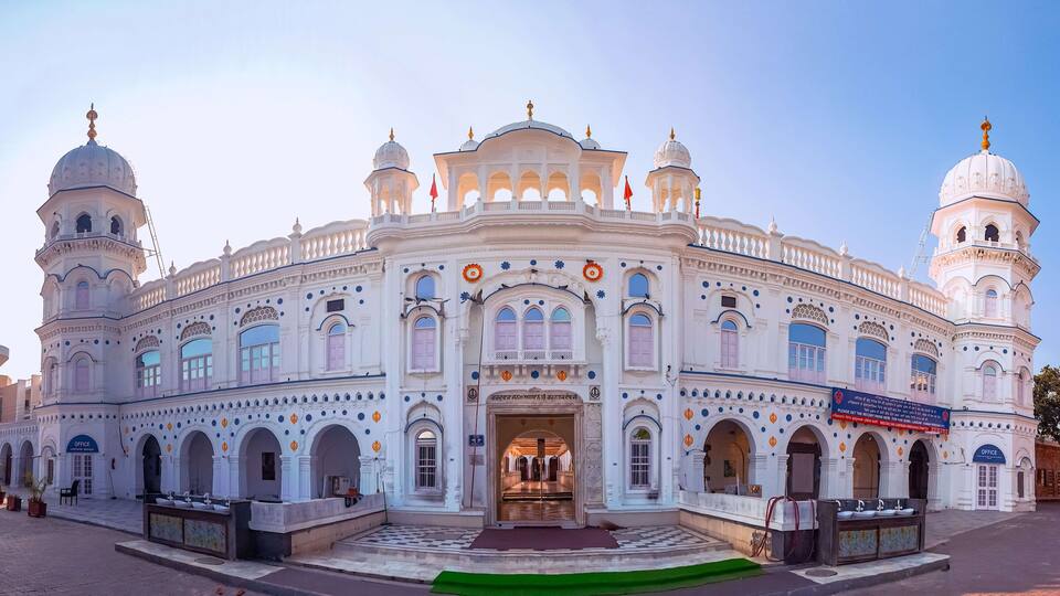A large, ornate building with multiple domes and arches, featuring a prominent entrance and several smaller windows.