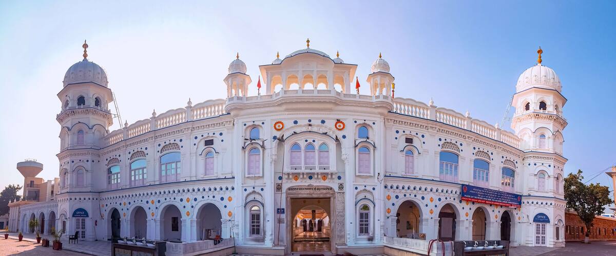 A large, ornate building with multiple domes and arches, featuring a prominent entrance and several smaller windows.